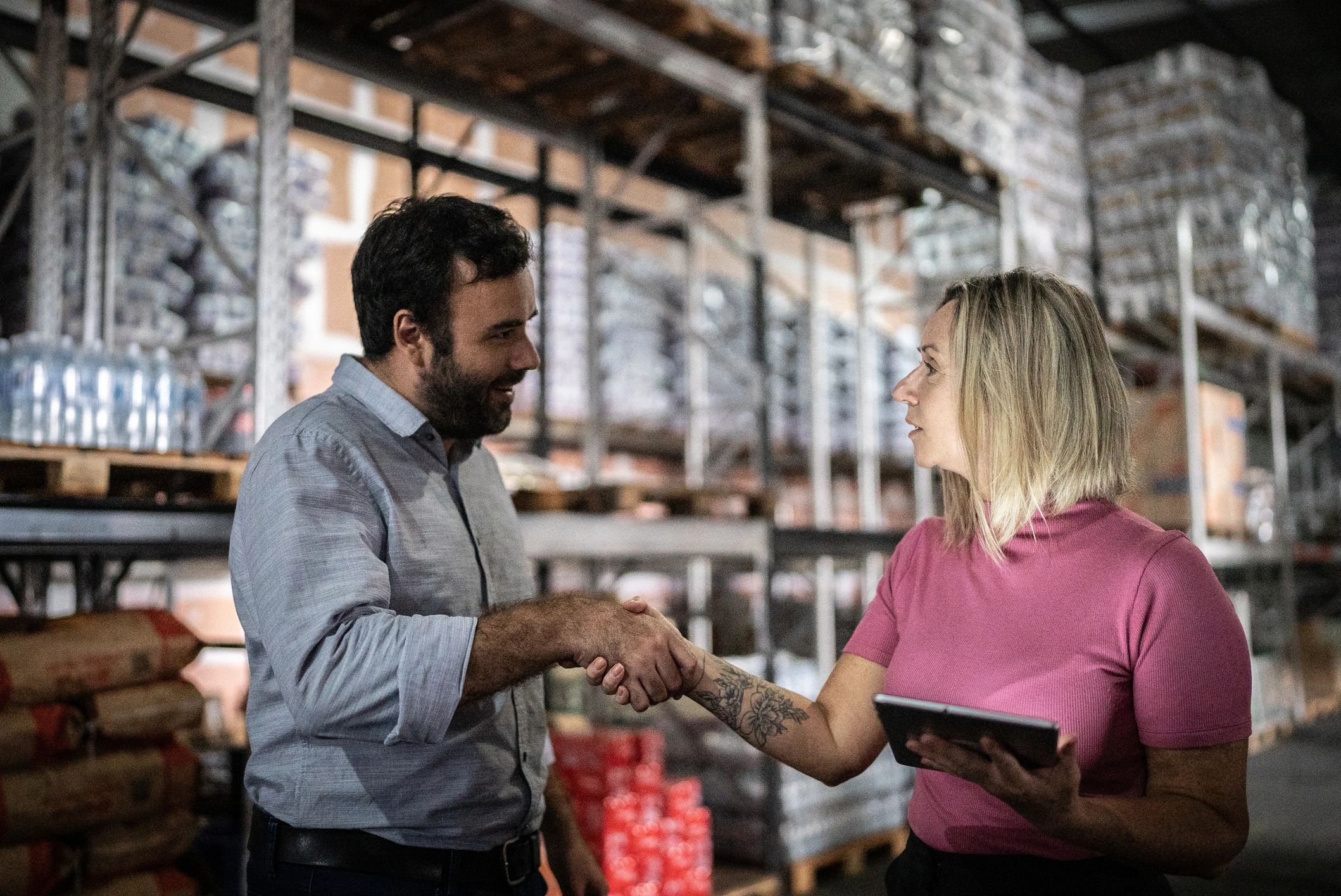 Business partners shaking hands in a warehouse