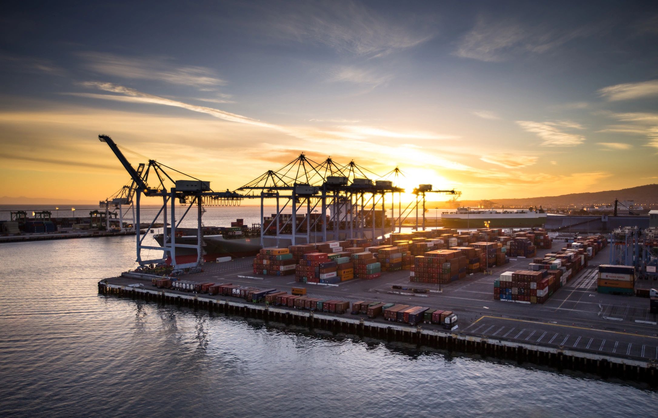 Container port logistics at sunset